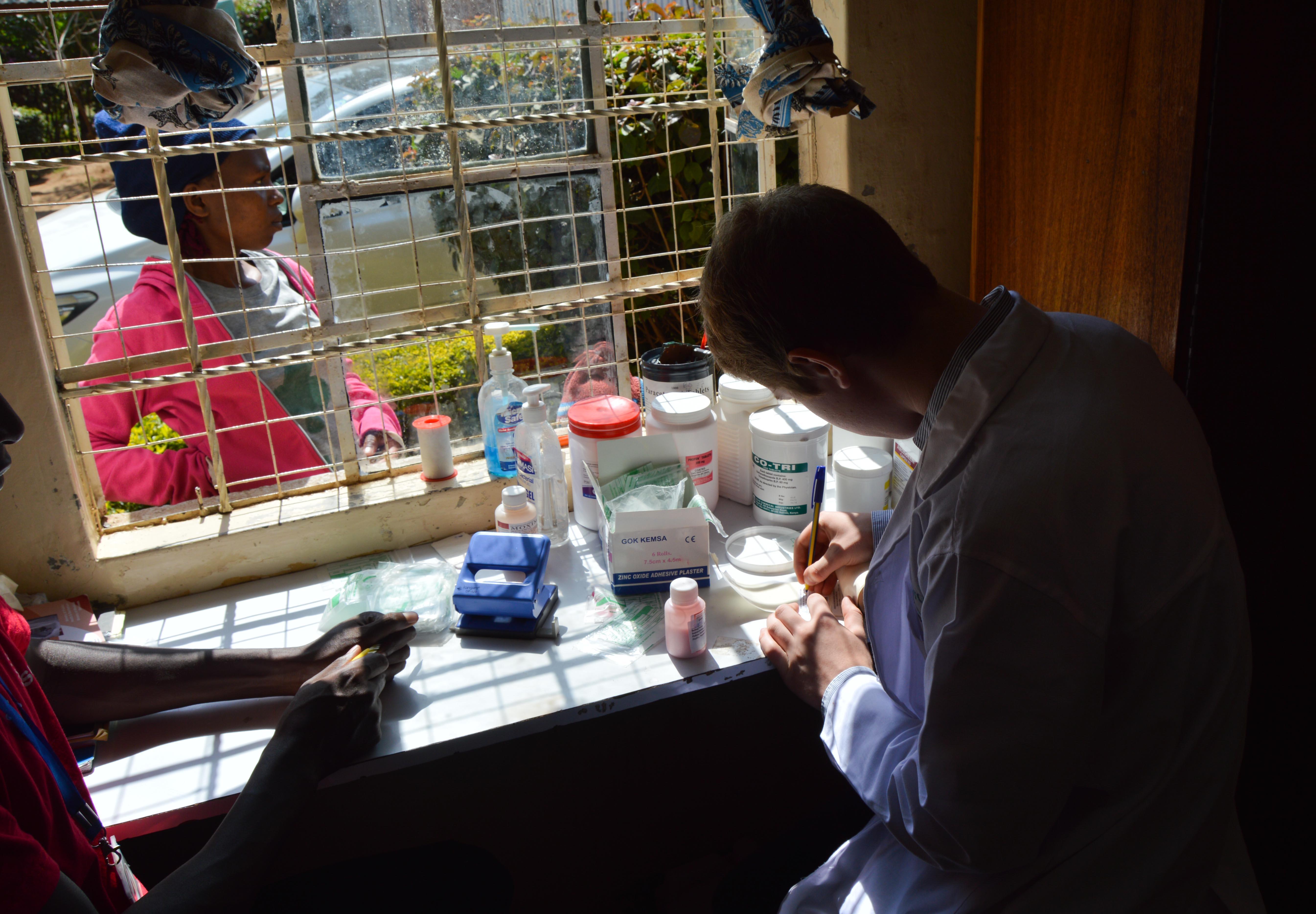 Help sort medical prescriptions as part of a work placement or pharmacy internship in Ghana with Projects Abroad. A local doctor is pictured organising medical prescriptions whilst a placement student with projects abroad whilst on her pharmacy internship in Ghana watches over.